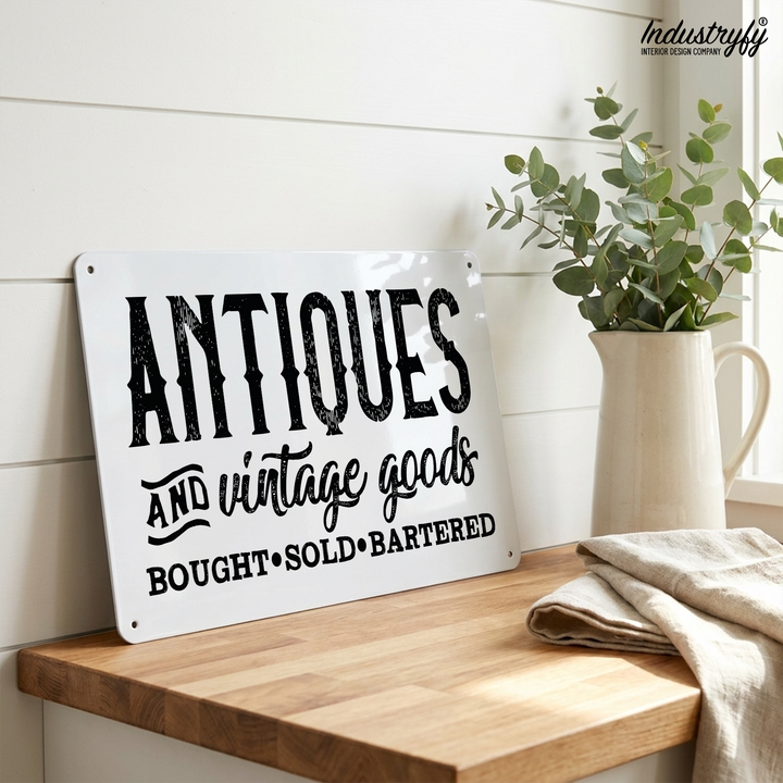 Vintage Metallschild Antiques and vintage goods angelehnt auf Holzboard mit Eukalyptus im Landhausstil
